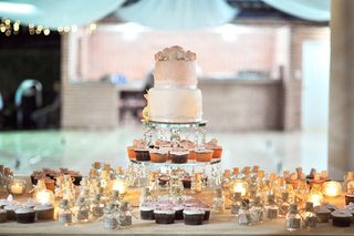 Mesa de pastel para boda decorada con velas y postres