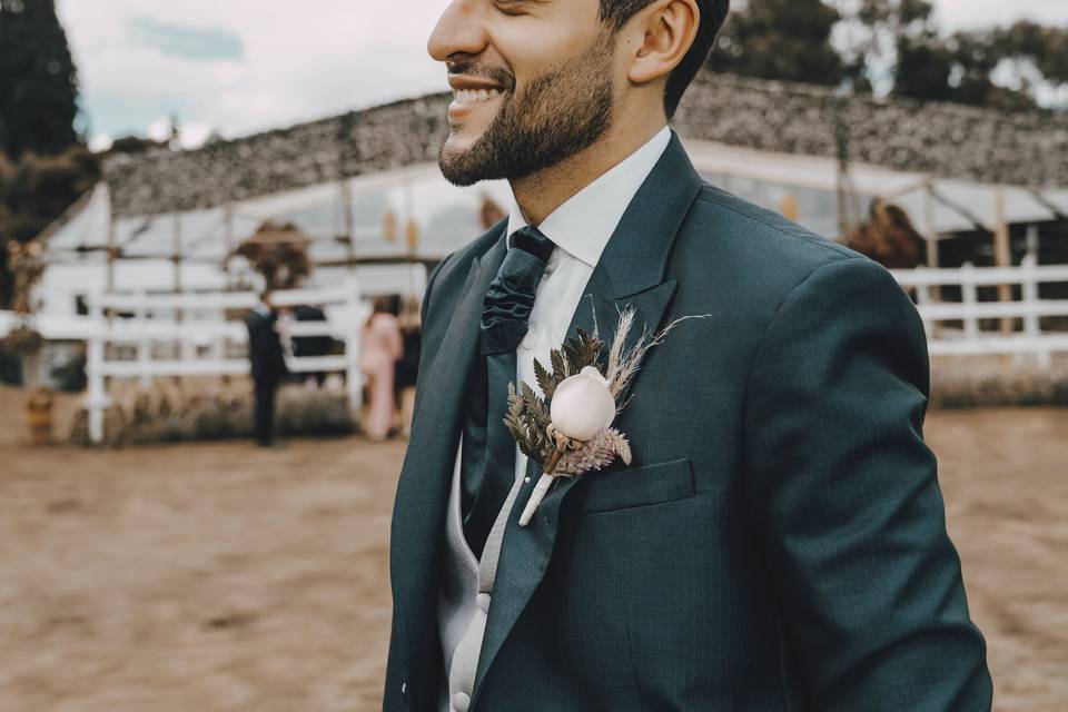 Traje de novio verde de tres piezas con boutonnière o gallardete