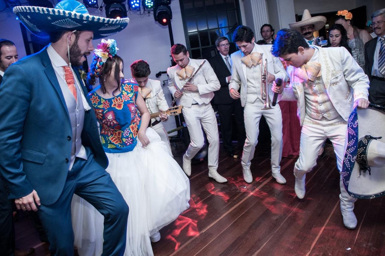 Novio y novia bailando con el grupo de mariachi en la fiesta de boda