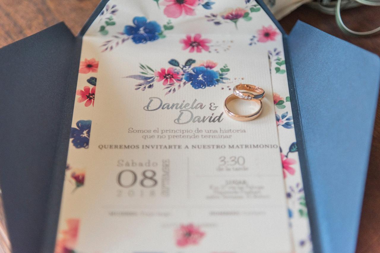 Invitación de boda floral con argollas de matrimonio