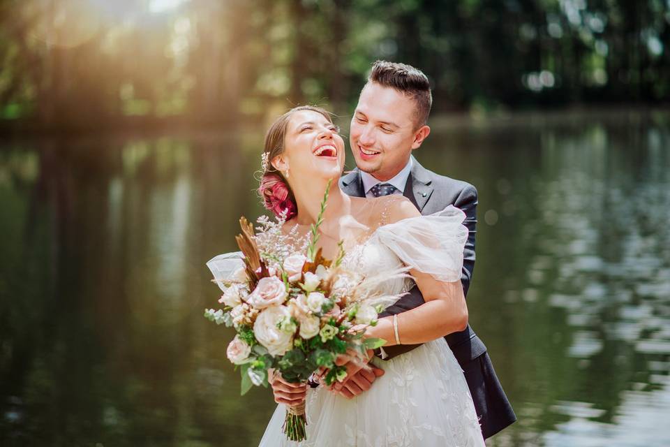 Pareja de recién casados sonrientes en sesion de fotos al aire libre