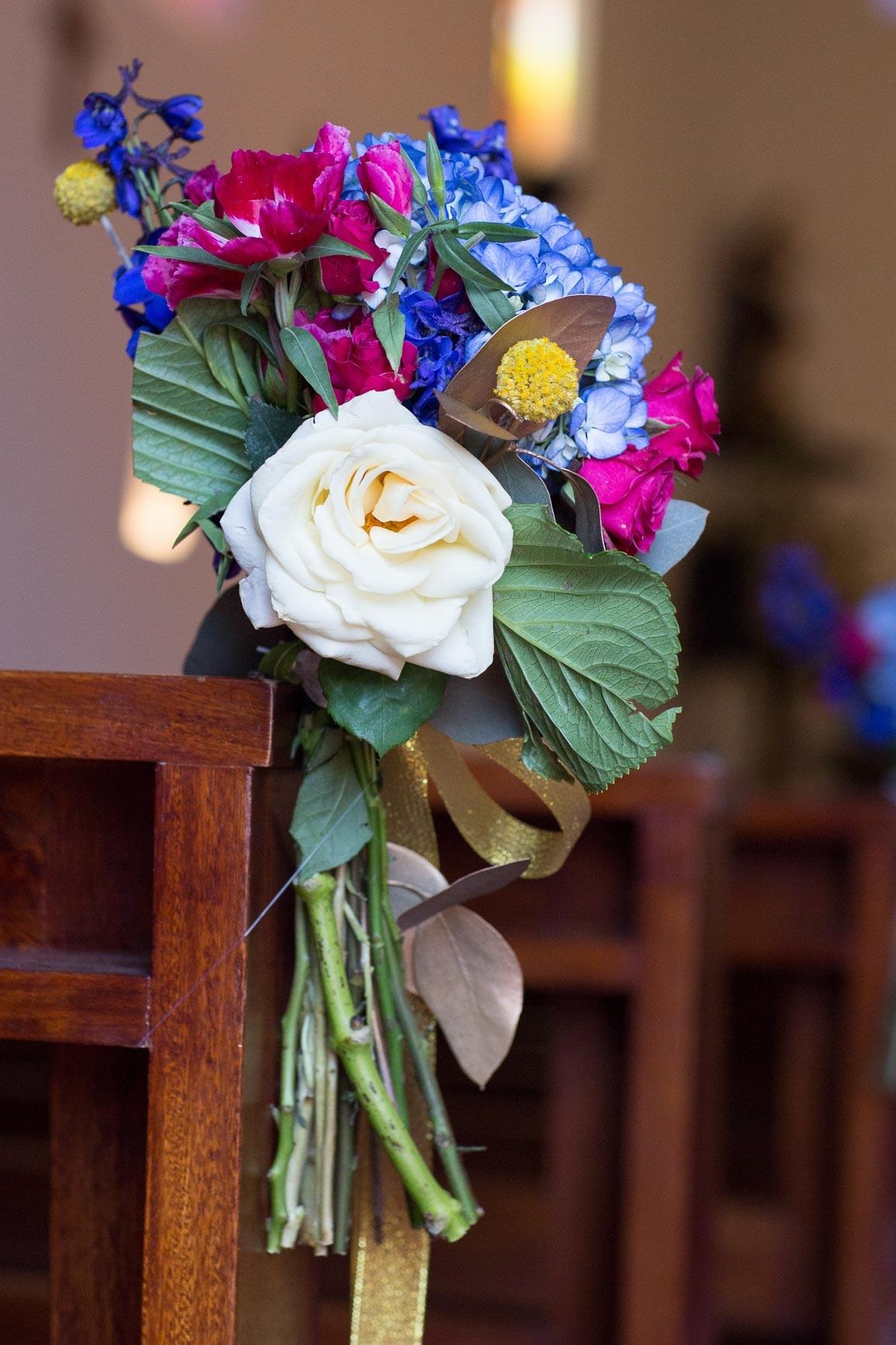 composición de flores para sillas de iglesia para matrimonio