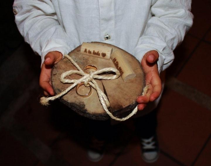 pajecito sostiene retablo de madera con argollas de matrimonio