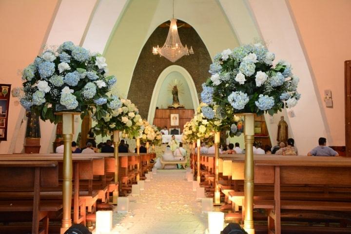 Decoración para matrimonio en iglesia con velas y arreglos de flores elegantes
