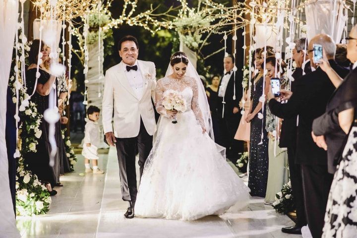 padre e hija caminando hacia el altar para la boda