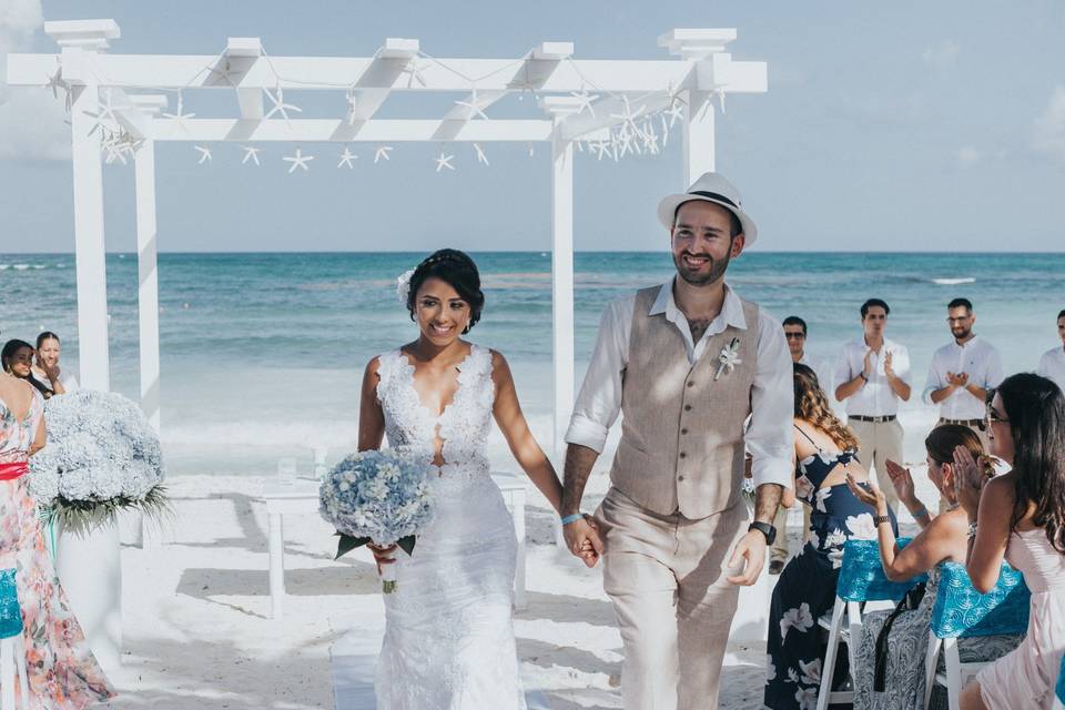 Saida de novios de su ceremonia en la playa