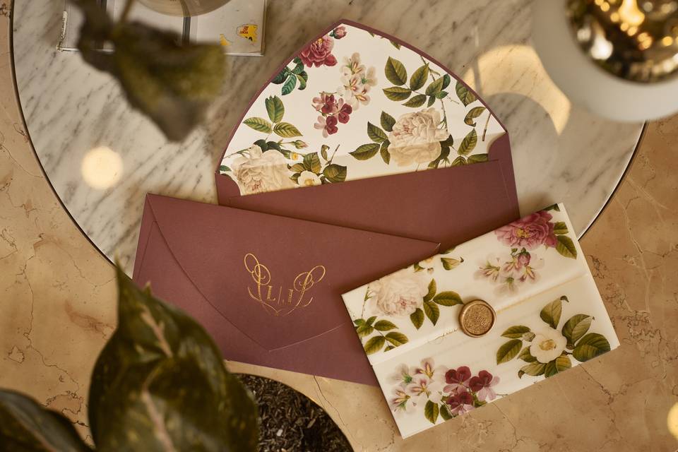 contenido de una invitación de boda con diseño floral en color café