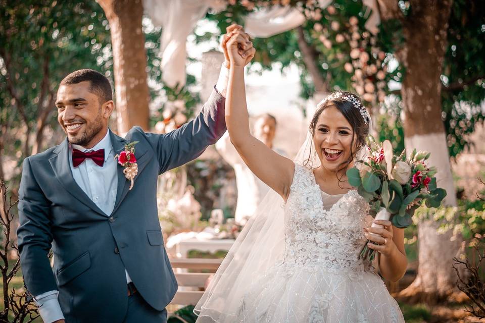 Pareja feliz saliendo de su ceremonia  de boda al aire libre