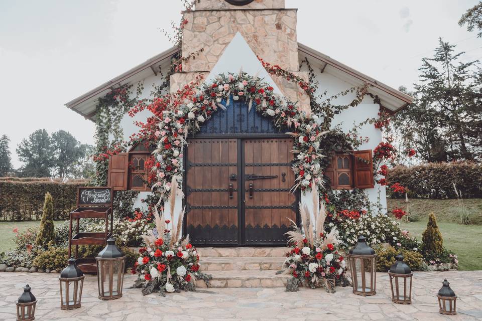 Iglesia decorada para boda con arco de flores y faroles