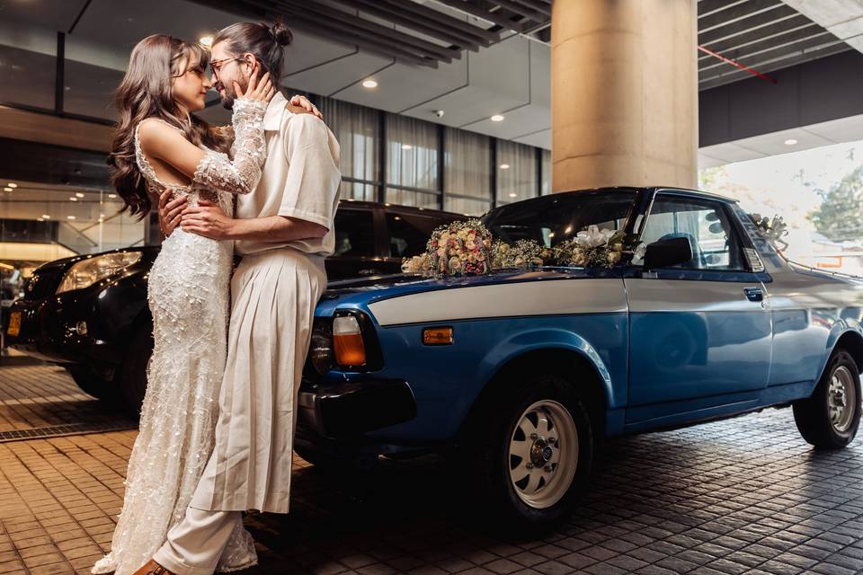 Novios junto a carro antiguo