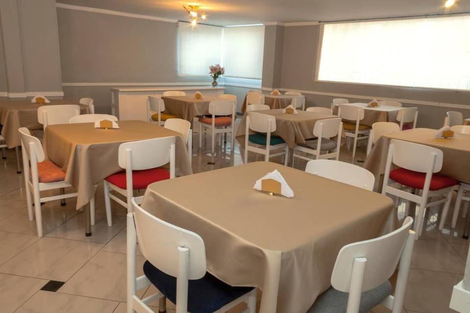 Salón de eventos con mesas cuadradas