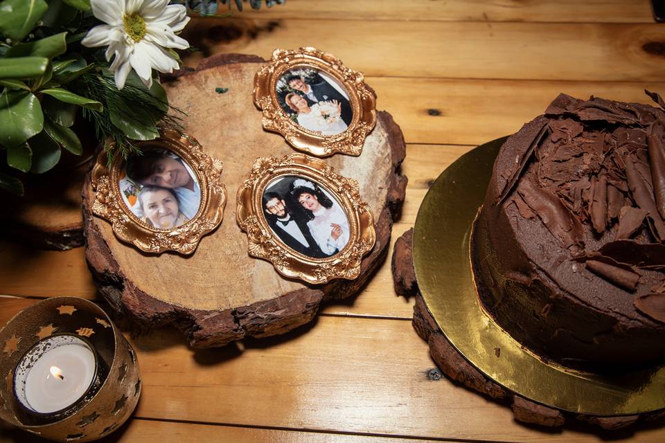 Retratos en un trozo de madera y a lado el ponqué de chocolate