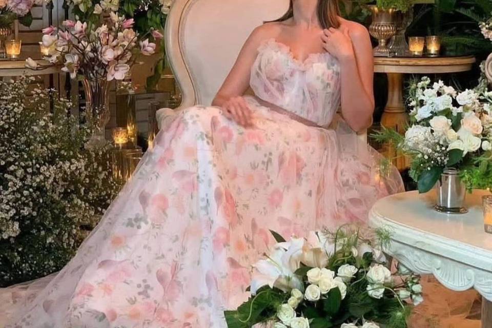 Novia sentada en un salón con ramos de flores