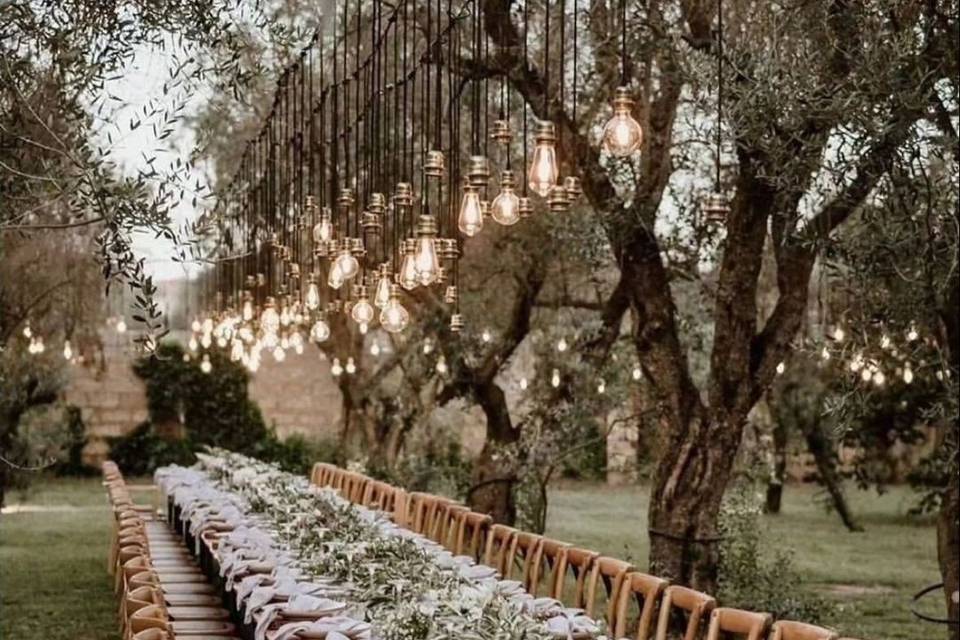 Mesa decorada en un jardín con luces