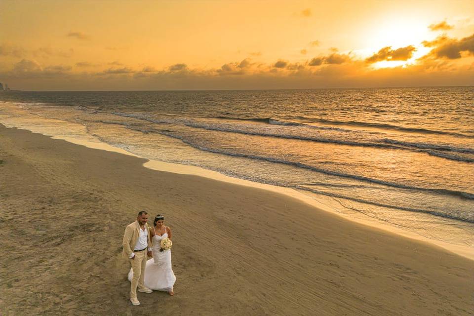 Pareja caminando en la playa al atardecer