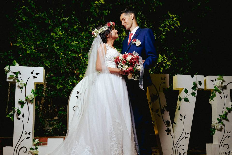 Pareja posando frente a las letras blancas