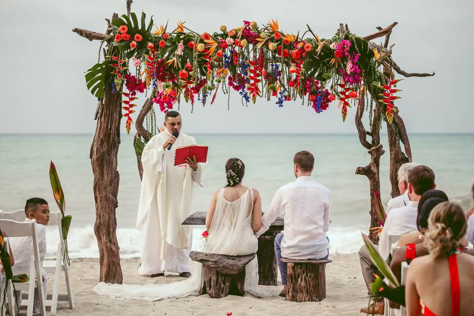 Novios sentados en el altar de la playa