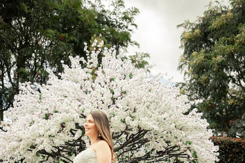 Novia en jardín de perfil con vestido blanco