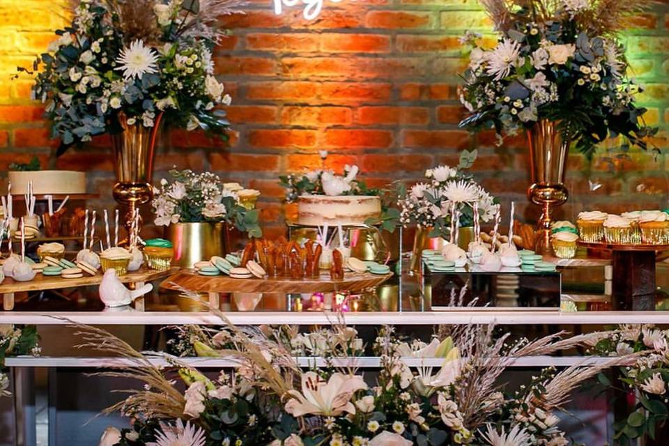 Letrero neón con mesa de dulces y arreglos florales