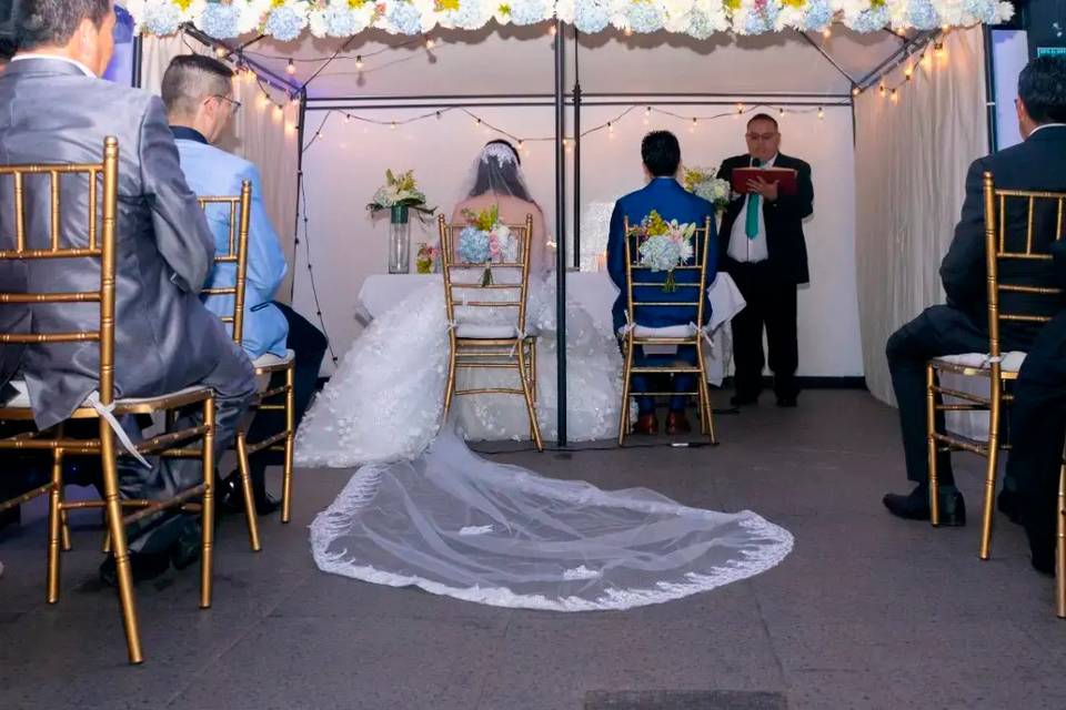 Novios sentados en el altar frente a sus invitados