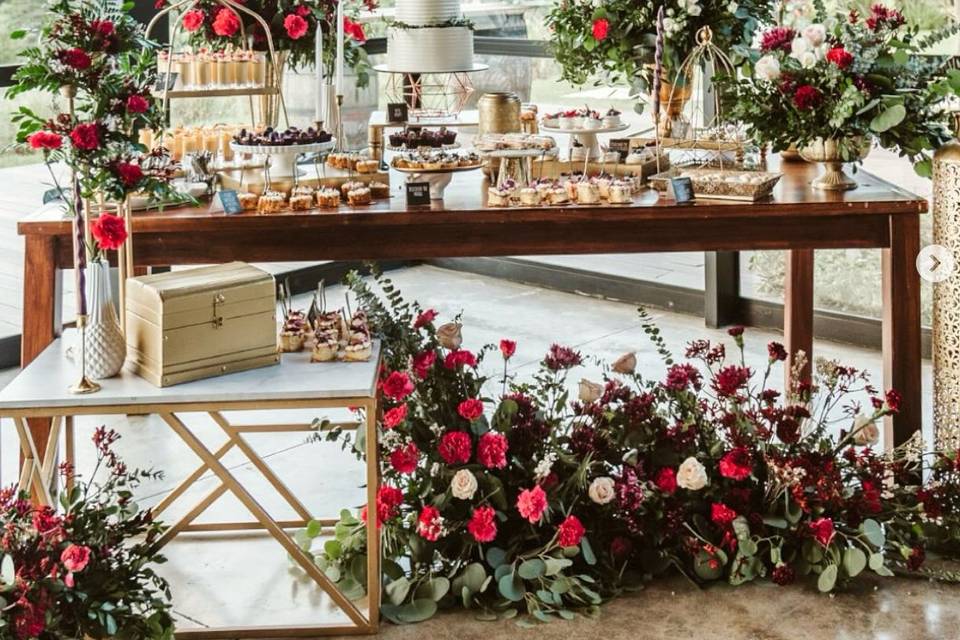 Mesa de postres con flores rojas