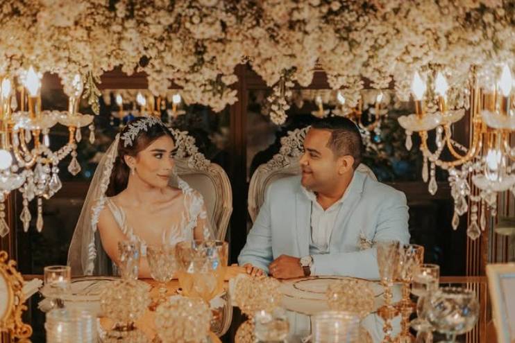 Novios sentados en su mesa decorada con flores