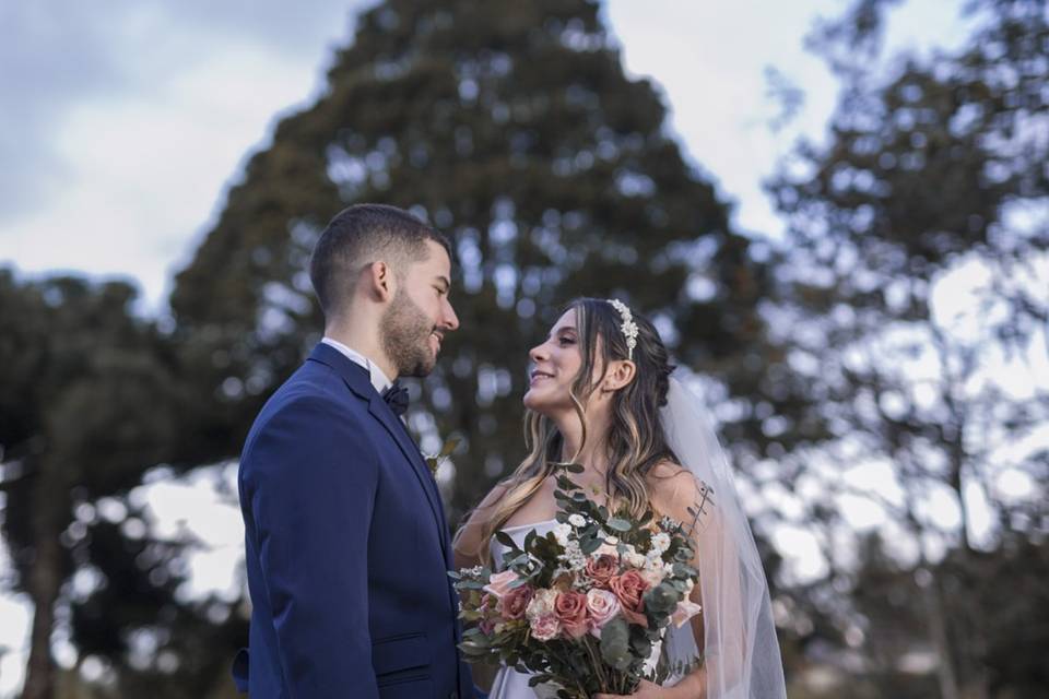 Novios viéndose y posando en un jardín