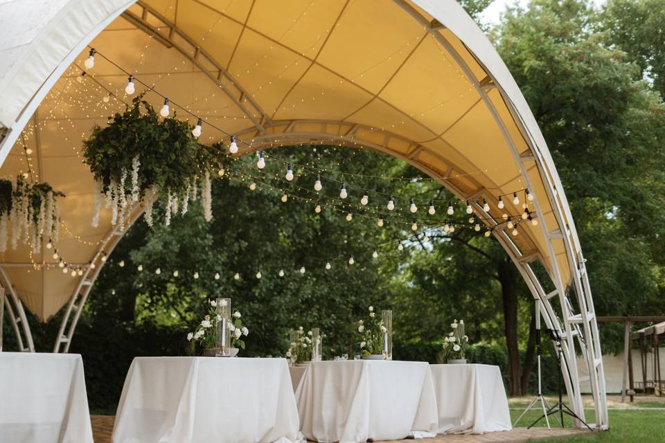 Carpa en jardín con luces y mesas