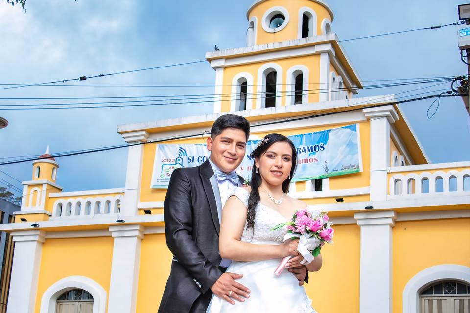 Novios posando frente a la iglesia