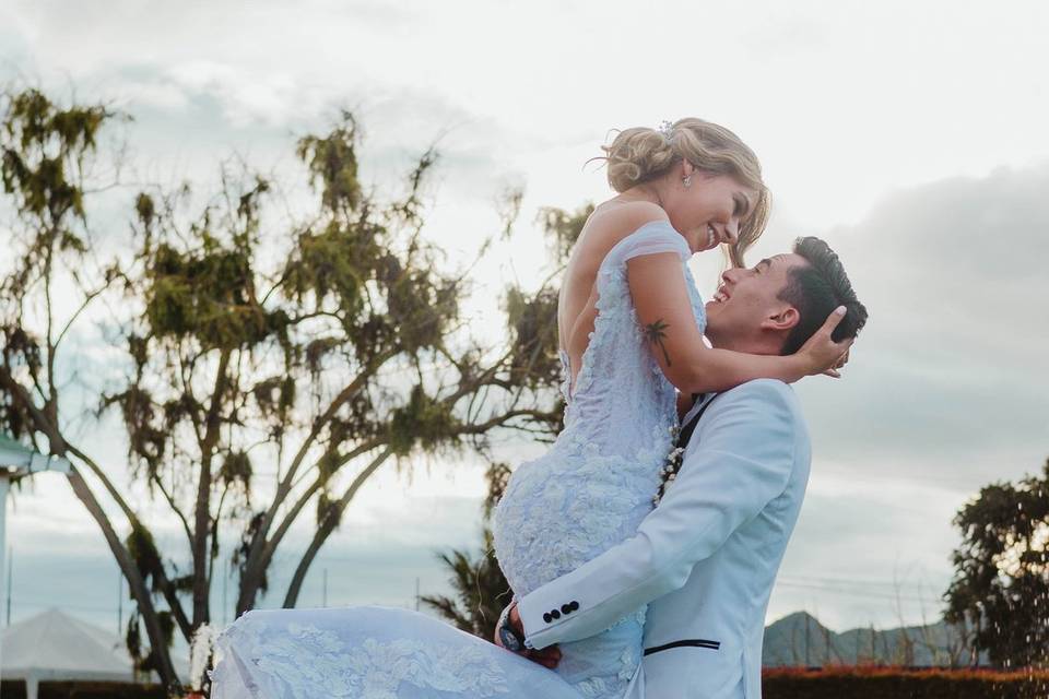 Novio cargando a la novia en el jardín