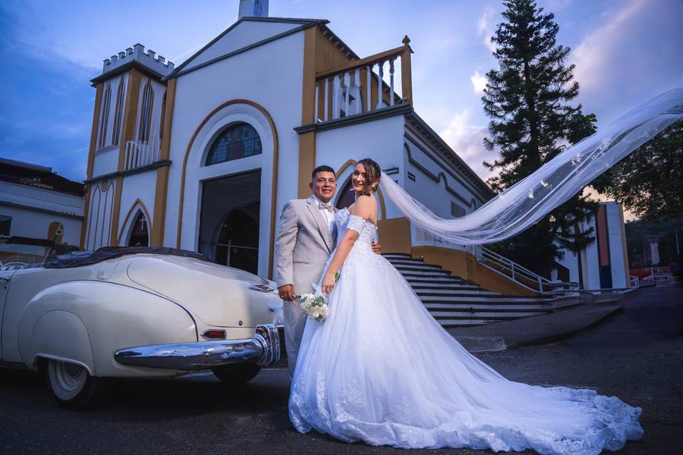 Novios posando frente a la iglesia