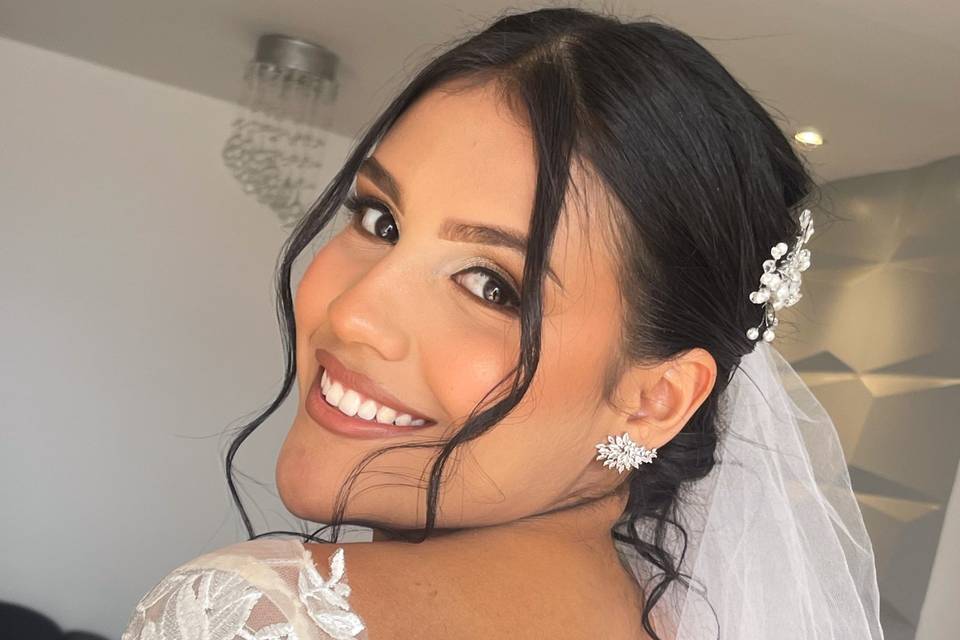 Novia sonriendo con cabello recogido y velo bajo