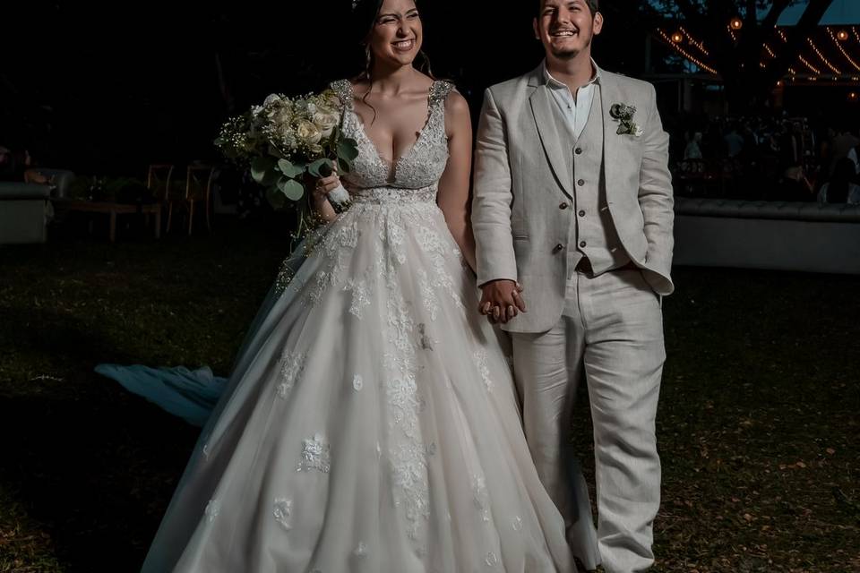 Novios tomados de la mano en la noche al aire libre