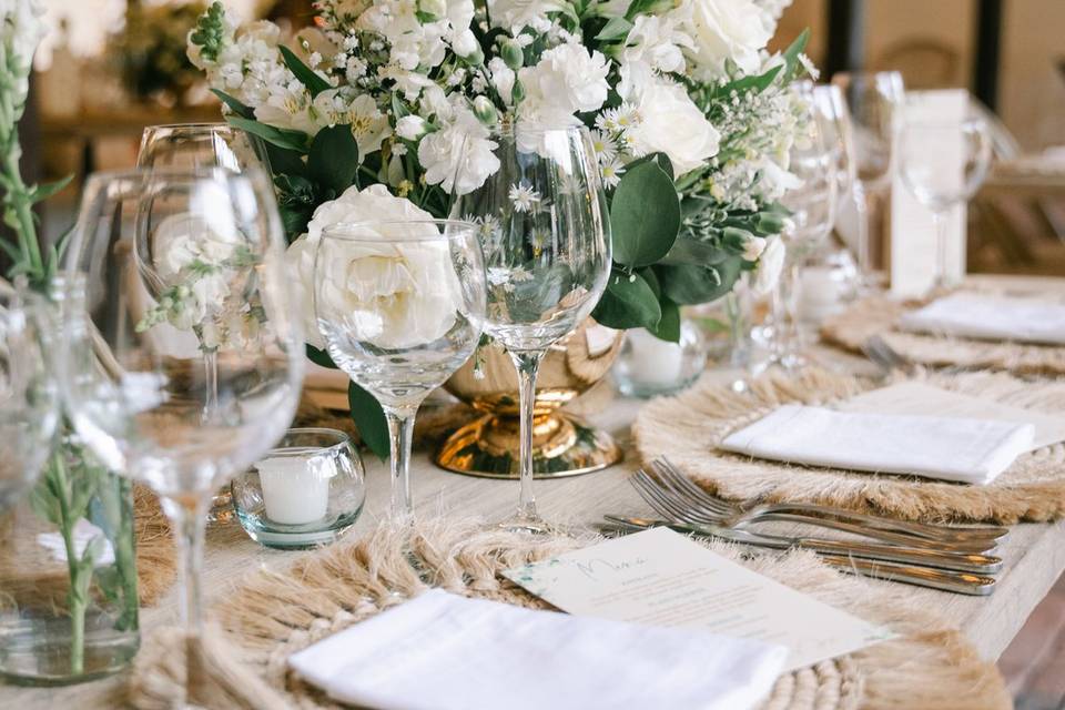 Mesa con copas de cristal y arreglo floral