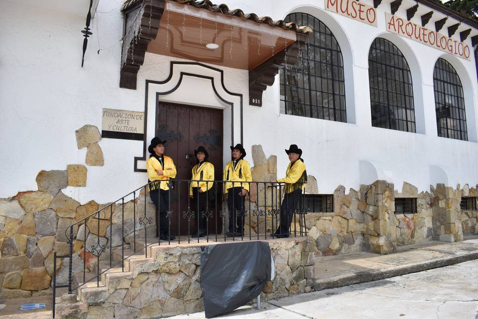 Músicos posando frente al portal de una casa