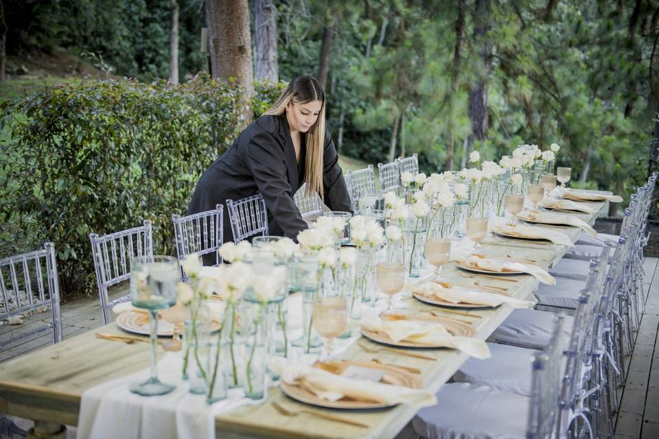 Mesa decorada con cristalería, flores y vajilla