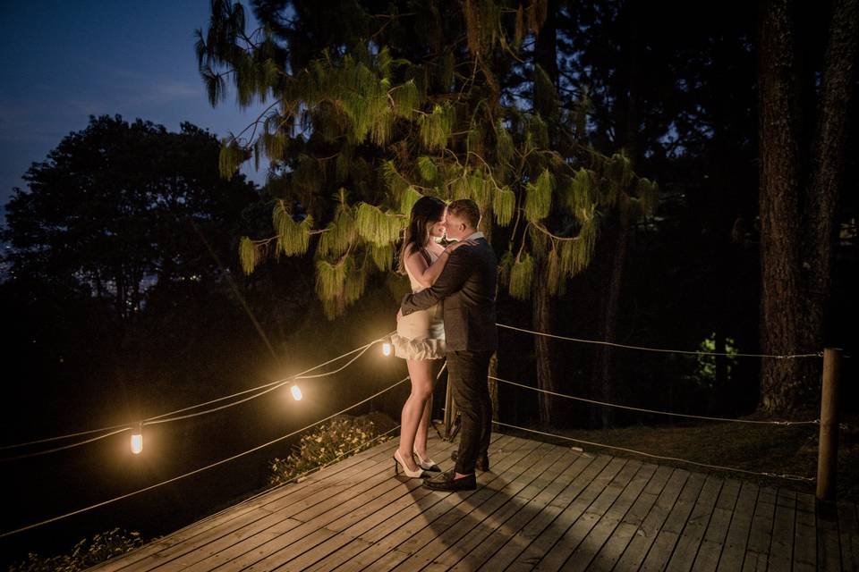 Pareja abrazada en la terraza iluminada