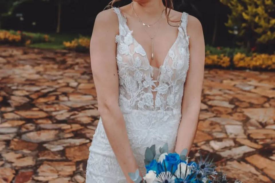 Novia sonriente con un vestido en escote V y ramo azul