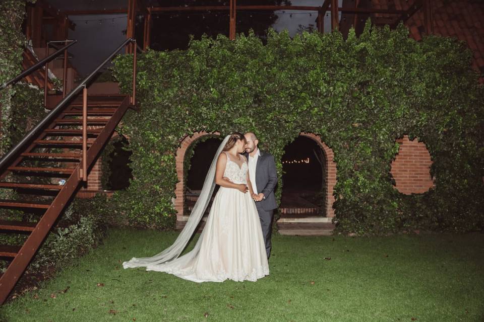 Novios posando en el jardín de noche