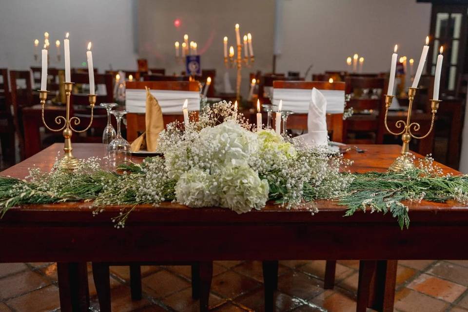 Mesa decorada con flores blancas y velas