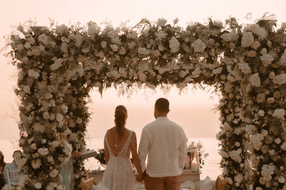 Novios casándose en un altar lleno de flores