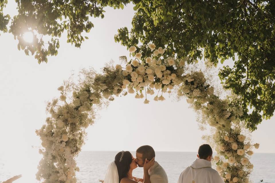 Novios besándose en su altar de bodas frente al mar