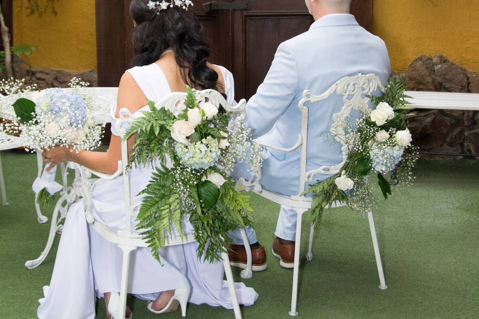 Novios de espaldas sentados en un jardín