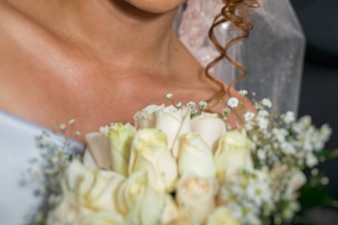 Novia sonriendo con su ramo de flores blancas