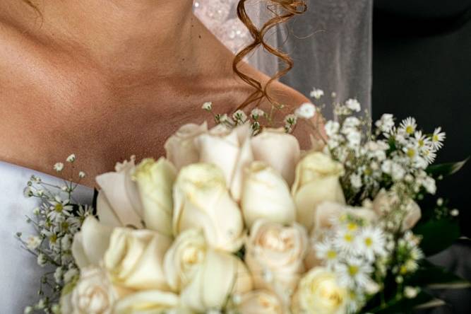 Novia con rizos y ramo de rosas blancas