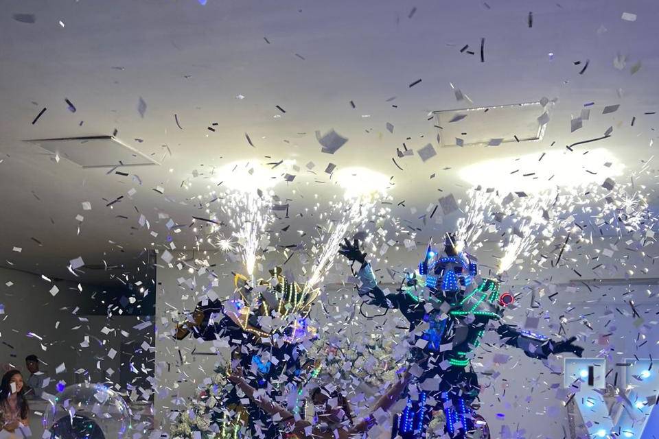 Novios en medio de la pista con un robot led y papelitos