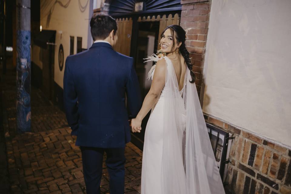 Novios de espaldas caminando de la mano
