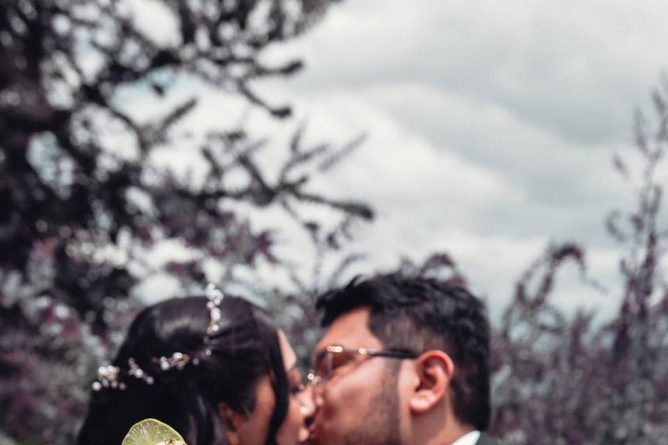 Novios besándose y mostrando las copas