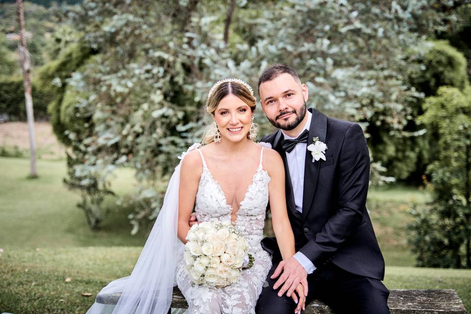 Novios sentados en un banco de un jardín